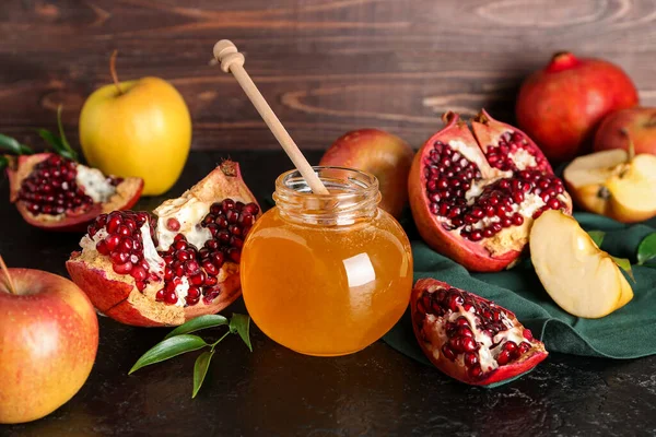 Rosh Hashanah kutlaması için kavanoz bal, nar ve elma (Yahudi Yeni Yılı) siyah masada