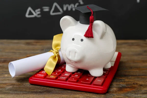 Piggy Bank Graduation Cap Diploma Calculator Brown Wooden Table Blackboard — Stock Photo, Image