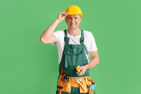 Ältere Bauarbeiter Mit Maßband Auf Grünem Hintergrund — Stockfoto