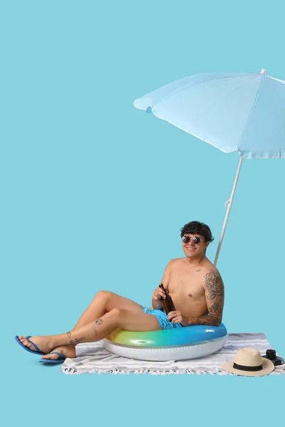 Mladý Muž Pivem Plážové Doplňky Sedí Modrém Pozadí — Stock fotografie