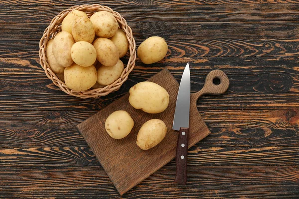 Weidenschale Und Brett Mit Rohen Kartoffeln Auf Holzgrund — Stockfoto