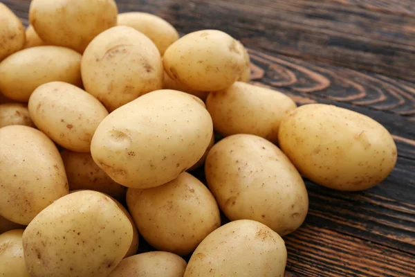 stock image Many raw potatoes on wooden background