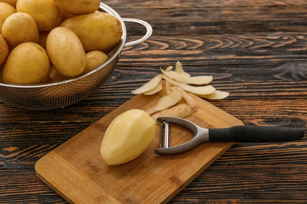 Brett Und Sieb Mit Rohen Kartoffeln Auf Holzgrund — Stockfoto
