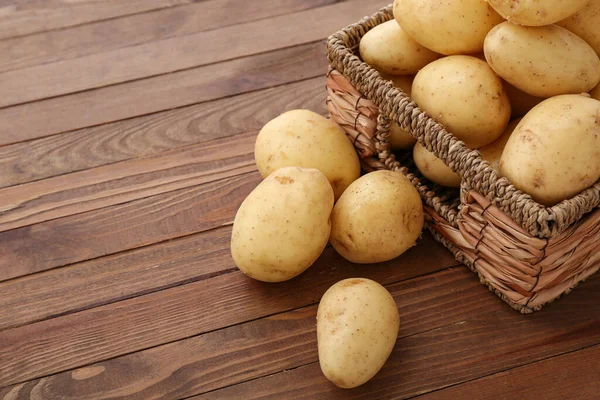 Weidenschachtel Mit Rohen Kartoffeln Auf Holzgrund — Stockfoto