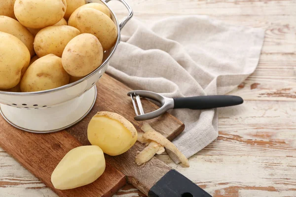 Sieb Und Platte Mit Rohen Kartoffeln Auf Weißem Holzgrund — Stockfoto