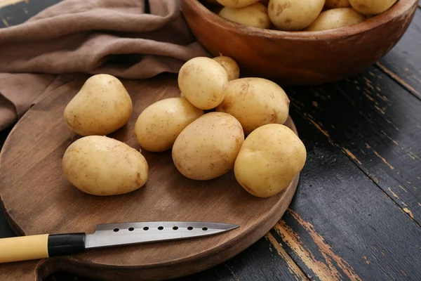 Brett Mit Rohen Kartoffeln Auf Schwarzem Holzgrund — Stockfoto