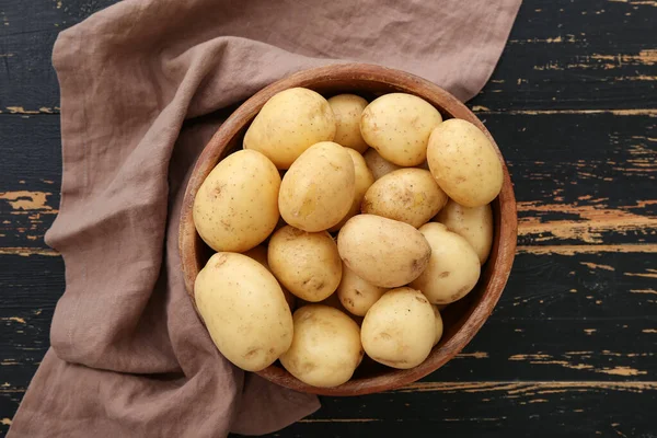 Schüssel Mit Rohen Kartoffeln Auf Schwarzem Holzhintergrund — Stockfoto