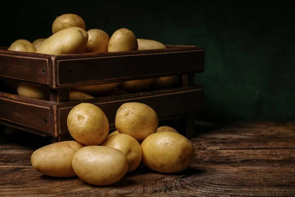 stock image Box with raw potatoes on wooden table