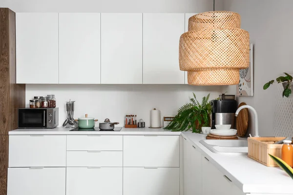 白いカウンター 食器棚 ランプ付きの光キッチンのインテリア — ストック写真
