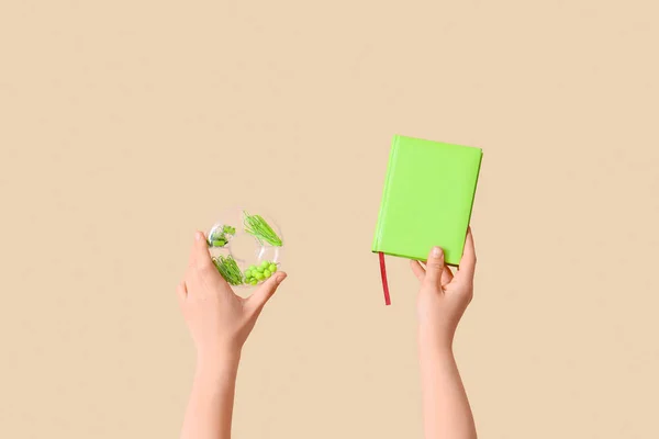 stock image Female hands holding book and case with stationery on beige background