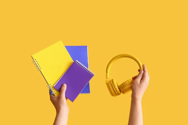 Manos Femeninas Sosteniendo Copybooks Auriculares Sobre Fondo Amarillo —  Fotos de Stock