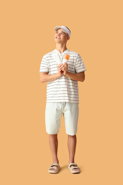 Happy Young Man Bottles Sunscreen Cream Orange Background — Stock Photo, Image