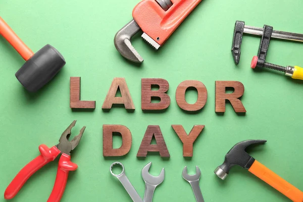 Composition with different tools and text LABOR DAY on green background