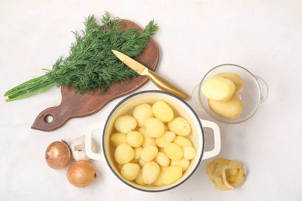Topf Und Schüssel Mit Geschälten Kartoffeln Auf Hellem Hintergrund — Stockfoto