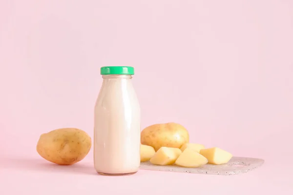 ピンクの背景においしいポテトミルクのボトル — ストック写真