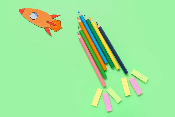Bleistifte Und Aufkleber Mit Papierrakete Auf Grünem Hintergrund — Stockfoto