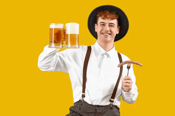 Молодой Человек Традиционной Немецкой Одежде Пивом Колбасой Желтом Фоне — стоковое фото