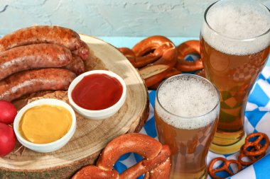 Soğuk bira bardakları ve mavi arka planda farklı atıştırmalıklar. Ekim Festivali Kutlaması