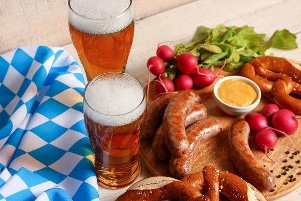 stock image Glasses of cold beer and plate with different snacks on light wooden background. Oktoberfest celebration