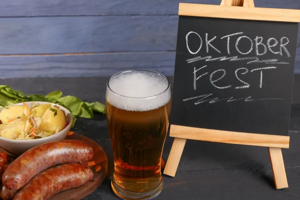 一杯冰镇啤酒 一块写有 Oktoberfest 字样的黑板和各种小吃放在桌上 — 图库照片