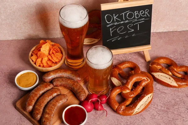 冰镇啤酒 带有单词Oktoberfest的黑板 粉红背景的不同小吃 — 图库照片