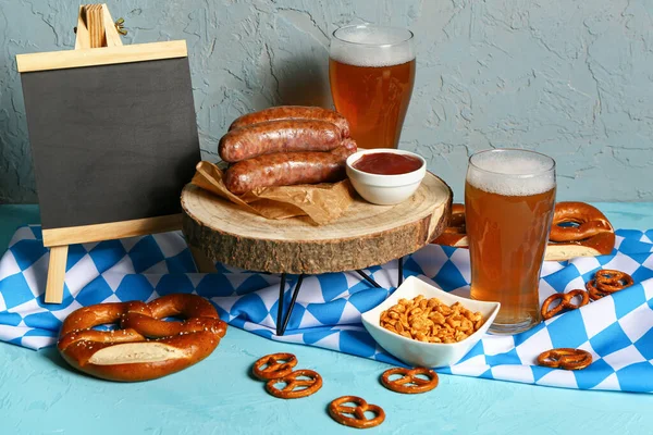 stock image Glasses of cold beer, blank chalkboard and different snacks on blue background. Oktoberfest celebration