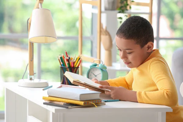 Pequeno Menino Afro Americano Lendo Livro Escolar Casa — Fotografia de Stock