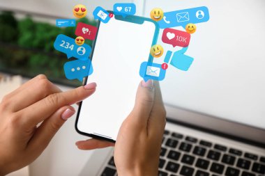 Cep telefonlu bir kadın iş yerinde internette sohbet ediyor.