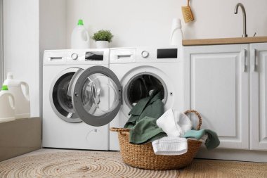 Çamaşır odasında kirli çamaşırları olan modern çamaşır makineleri.