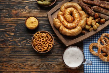 Bir bardak soğuk bira ve ahşap arka planda farklı atıştırmalıklar. Ekim Festivali Kutlaması