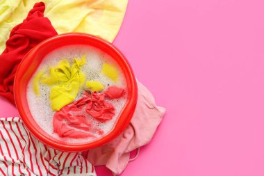 Kirli çamaşırları, suyu ve köpüğü olan plastik bir leğen.