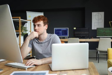 Ofiste bilgisayarla çalışan erkek programcı