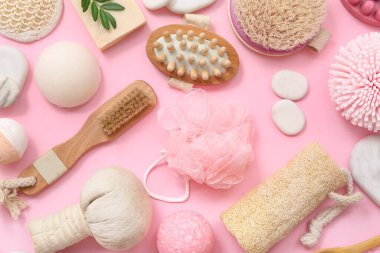 Pembe arka planda farklı banyo aksesuarları olan kompozisyon