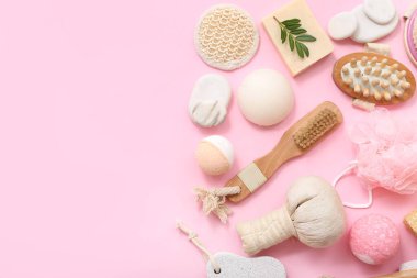 Pembe arka planda farklı banyo aksesuarları olan kompozisyon