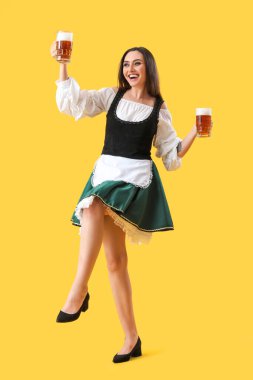 Sarı arka planda bira dansı yapan güzel Ekim Festivali garsonu.