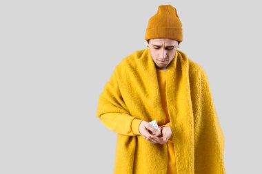 Hafif arka planda hapları olan hasta bir genç adam.