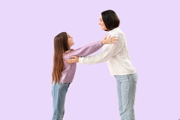 小さな女の子と彼女の母親で暖かいですセーター巨大上のライラック背景 — ストック写真