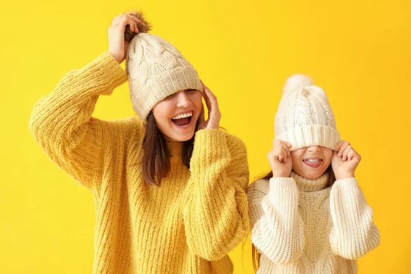 Zabawna Dziewczynka Jej Matka Ciepłych Kapeluszach Swetrach Żółtym Tle — Zdjęcie stockowe