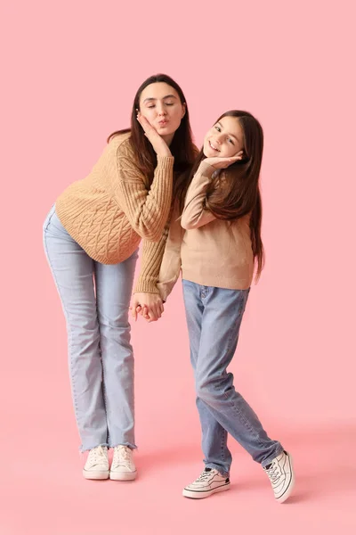小さな女の子と彼女の母親で編んだセーターホールディング手上のピンクの背景 — ストック写真