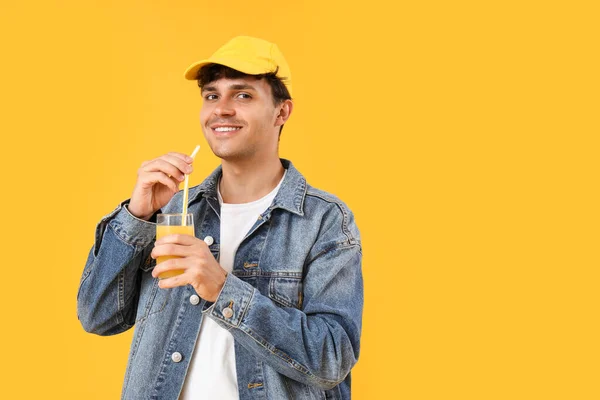 若いです男とともにオレンジジュースのガラスで黄色の背景 — ストック写真