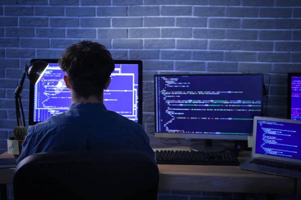 夜間にオフィスでコンピュータを操作する男性プログラマー — ストック写真