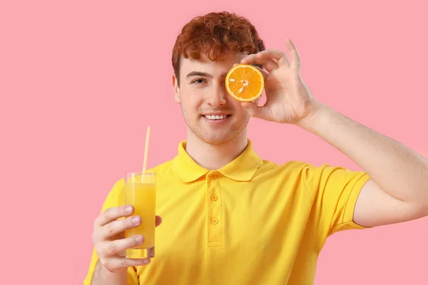 Junger Mann Mit Orange Und Einem Glas Saft Auf Rosa — Stockfoto
