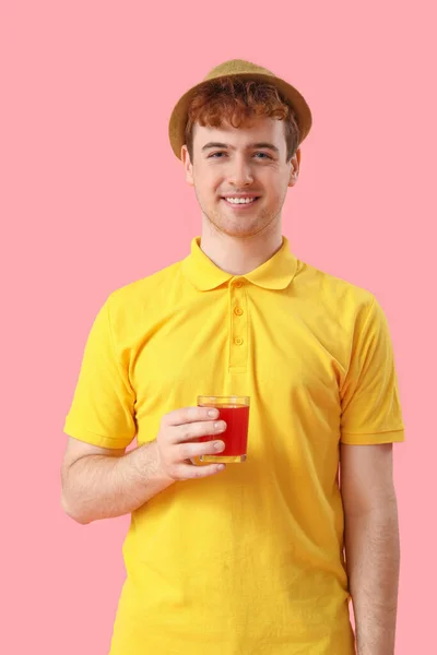 Młody Człowiek Szklanką Czerwonego Soku Różowym Tle — Zdjęcie stockowe