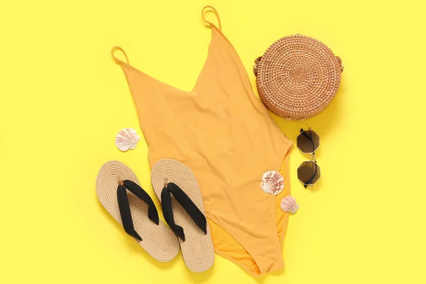 stock image Stylish swimsuit, bag, sunglasses, flip-flops and seashells on color background