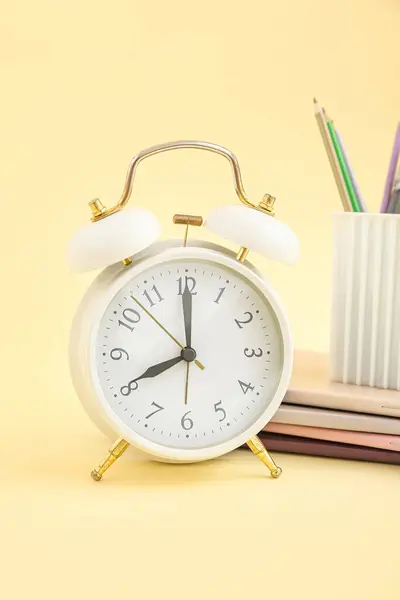 Reloj Despertador Con Cuadernos Soporte Papelería Sobre Fondo Amarillo — Foto de Stock