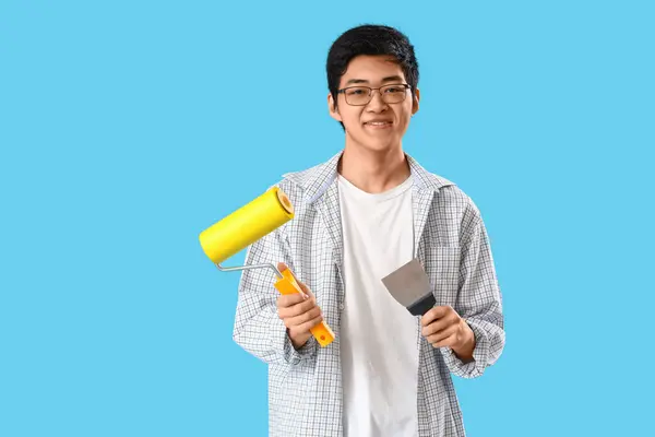 Young Asian Man Putty Knife Paint Roller Blue Background — Stock Photo, Image