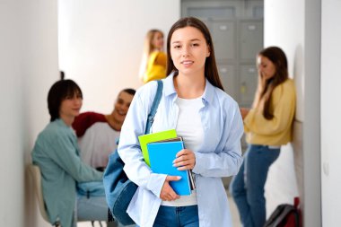 Okulda kitapları olan genç bir kız.