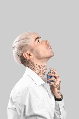 Parfümlü dövmeli genç bir adam.
