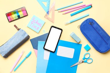 Sarı arkaplanda farklı kırtasiye ve cep telefonları bulunan SCHOL TIME isimli yapışkan bir not