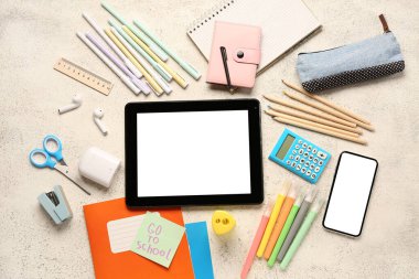 Yazılı yapışkan not Go to SCHOL, aygıtlar ve grunge beyaz arkaplan üzerinde farklı kırtasiye